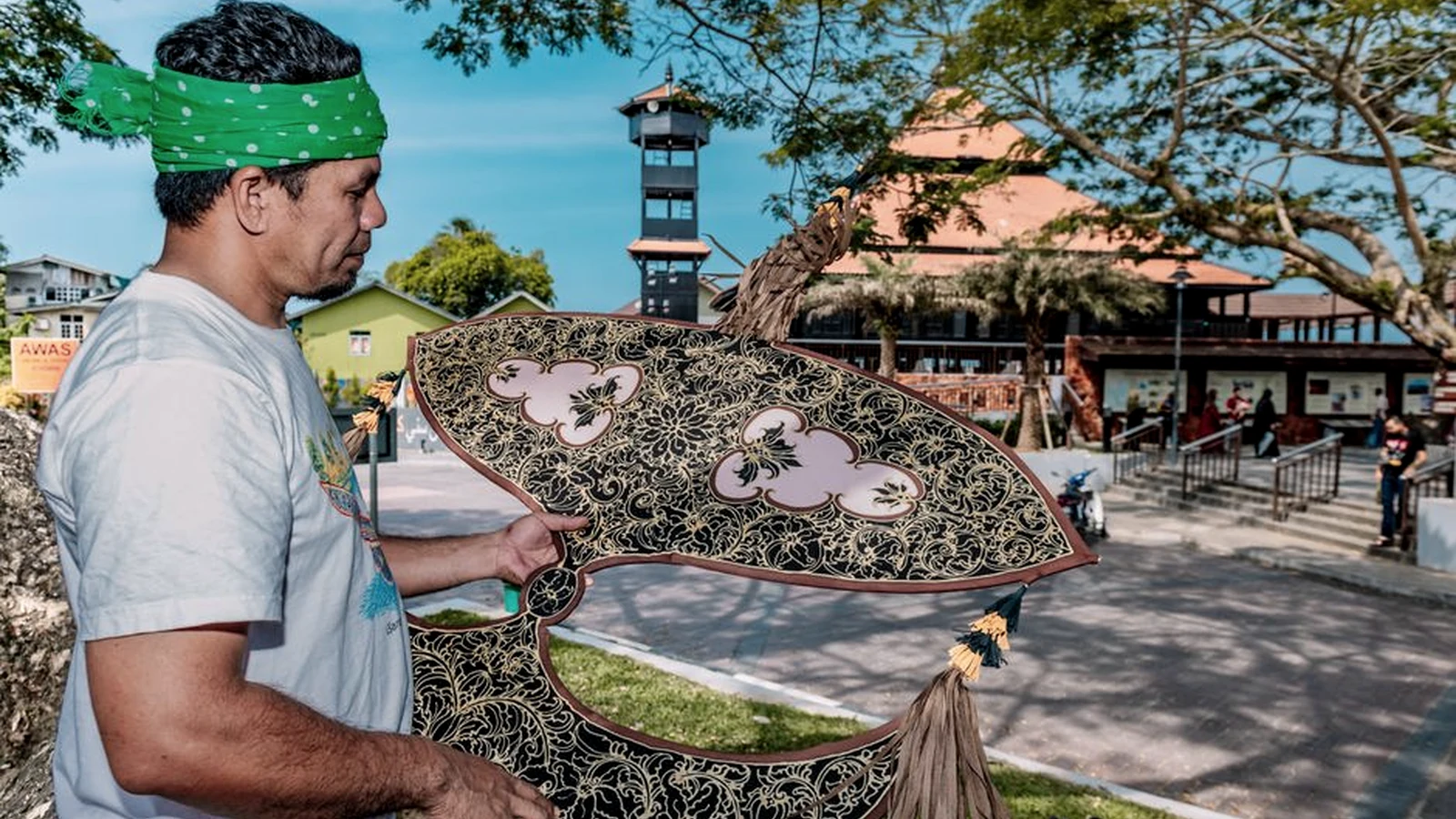 A traditional Malaysian wau kite held outdoors